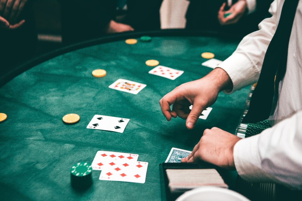 A person playing poker on a green table Description automatically generated